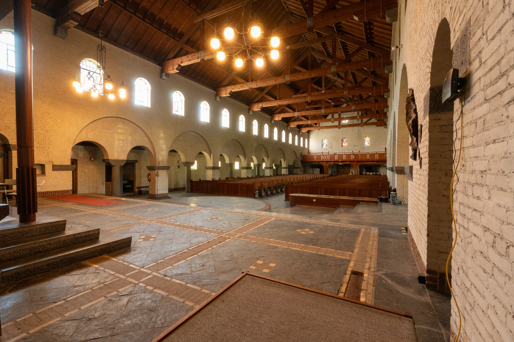 Het verhoogde altaar van de kerk met de monumentale houten kap.
