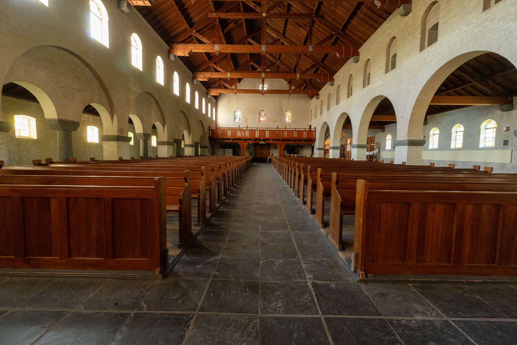 Het interieur van de kerk met de warme houten kap.